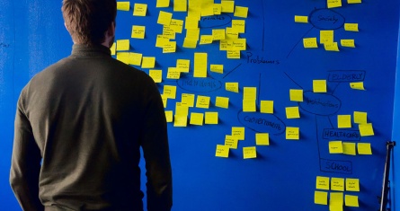 © Per Lööv - Unsplash [copyright] , Man in grey long-sleeved shirt standing in front of a blue and yellow puzzle mat 